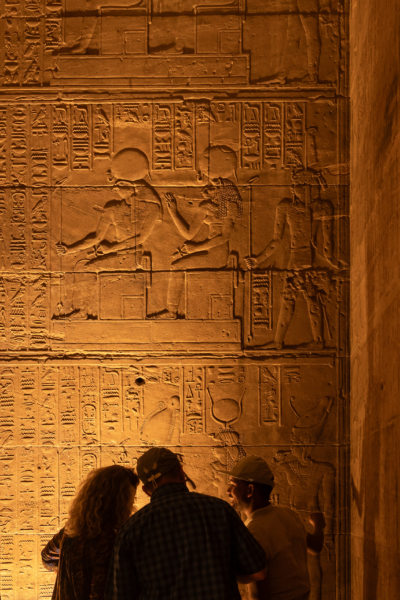 Touristes devant les hiéroglypes du temple de Philae en Egypte