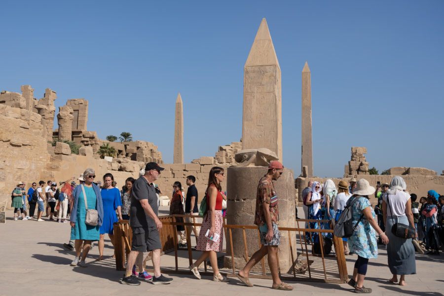 Touristes qui tournent autour du scarabée à Karnak