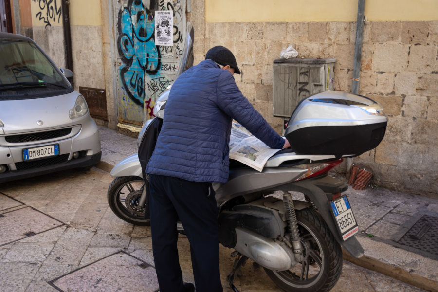 Lecture de journal sur un scooter